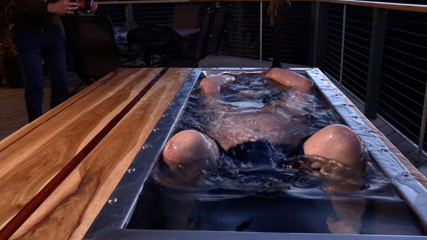 Man dunks head under water in cold plunge for recovery benefits
