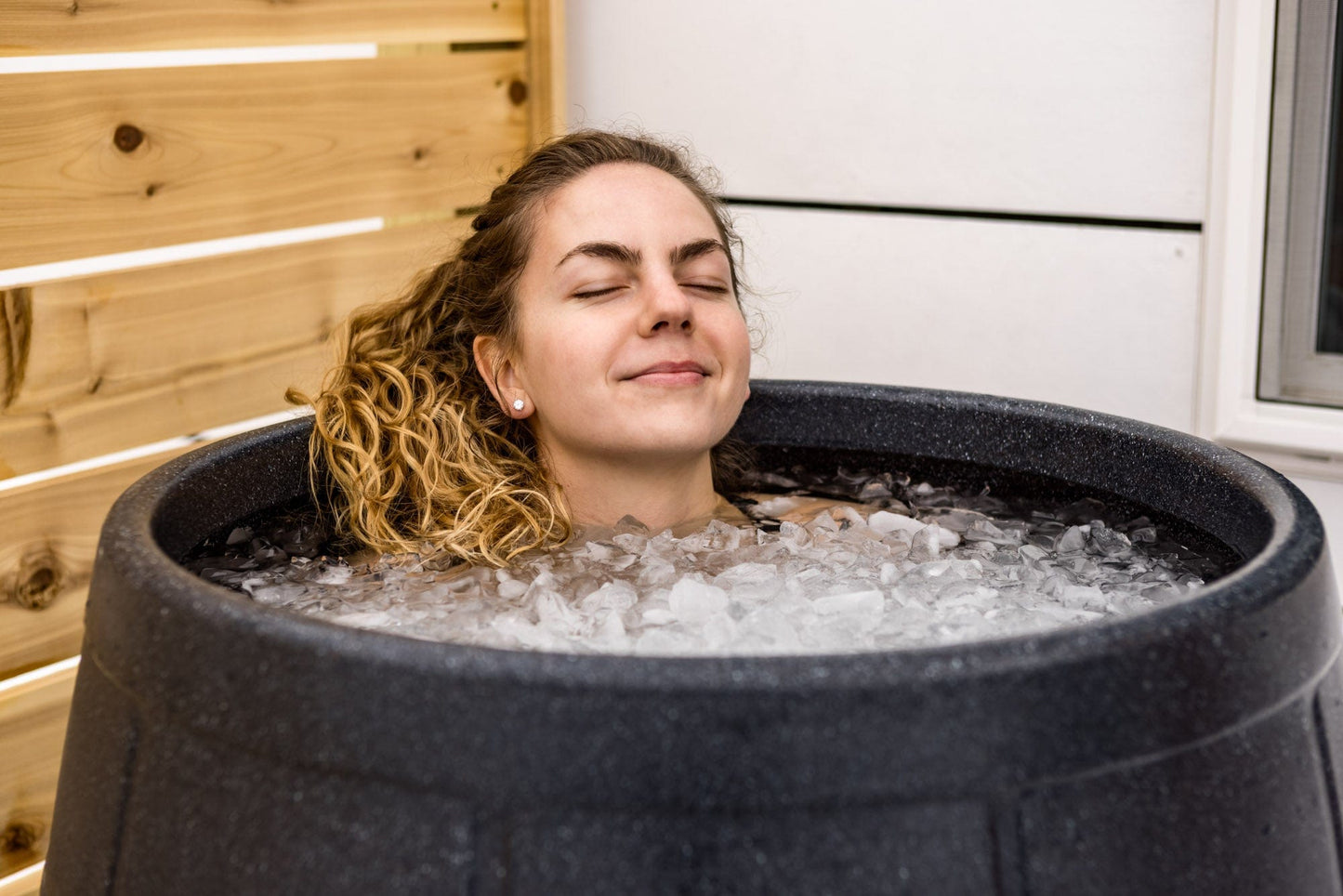 Satisfied woman chilling in an ice bath by Ice Barrel